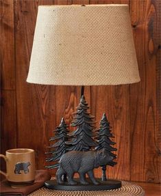 a bear lamp sitting on top of a table next to a coffee cup and mug