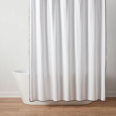 a white shower curtain with black piping