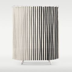 a black and white shower curtain with vertical stripes on the side, in front of a gray background