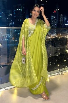 Lime green silk outer cape with placed pearl embroidered floral motifs on a bandhani pattern. Comes with padded embroidered blouse, draped skirt, potli and a saree drape. - Aza Fashions Diwali Sharara With Cutdana And Cape Sleeves, Festive Traditional Wear With Cutdana And Cape Sleeves, Navratri Dupatta With Cutdana And Cape Sleeves, Diwali Cutdana Sharara With Cape Sleeves, Traditional Dupatta With Cape Sleeves And Pallu, Festive Kaftan With Mirror Work And Cape Sleeves, Traditional Sharara With Gota Work And Cape Sleeves, Festive Kaftan With Dupatta And Cape Sleeves, Festive Mirror Work Kaftan With Cape Sleeves