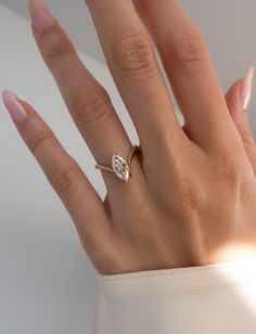 a woman's hand with a diamond ring on it