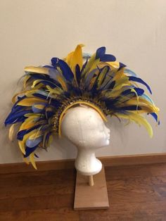 Do you want to be a showstopper at the party? This headpiece is perfect for you! Fun Summer Party Headpiece, Blue Headpieces For Carnival, Blue Costume Hats And Headpieces For Carnival, Blue Feathered Headpiece For Party, Yellow Fitted Costume Hats And Headpieces For Party, Fitted Yellow Party Costume Hats, Fitted Yellow Fascinator For Party, Yellow Party Headband Costume Accessory, Adjustable Yellow Costume Hats And Headpieces For Party