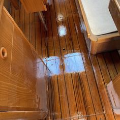 the wood floor in this bathroom has been stained brown and is being cleaned by someone