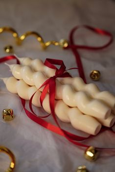 some kind of food on a table with red ribbon and gold bells in the background