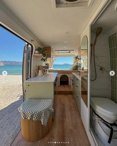 the inside of a camper with a view of the beach and ocean from it's kitchen