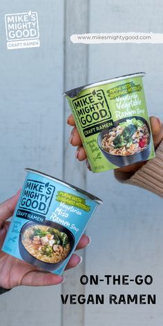 two people holding up bowls of food with the words on - the - go vegan ramen