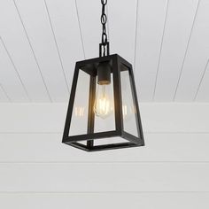 a light fixture hanging from the ceiling in a room with white walls and wood paneling