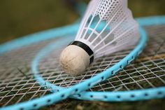 a tennis racquet with a ball on top of it next to another racket