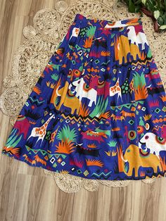 "Love this one so bright and cheerful. 80's Safari print midi skirt by Batya. Buttons on the side. Pockets at the hips. Bold colorful elephants, giraffes and antelope print. Purple, gold, black, green, and orange. Such a fun piece. In good vintage condition. Measurements taken while item was laying flat. Waist: 15\" Length: 35.5\"" Vibrant Print Summer Skirt, Vibrant Print Skirt For Summer, Playful Multicolor Skirt With Elastic Waistband, Multicolor Retro Skirt For Vacation, Retro Multicolor Skirt For Vacation, Summer Multicolor Print Skirt, Colorful Vibrant Summer Skirt, Vibrant Colorful Summer Skirt, Summer Multicolor Vibrant Print Skirt