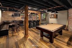 a game room with a pool table and bar