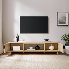 a living room scene with focus on the entertainment center and large screen tv mounted above it