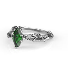 a green ring with leaves on the sides and an oval shaped stone in the middle