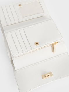 Small in size but big in style, the Huxley front flap wallet in white will help you ace your fashion game while keeping your belongings well-organised. Featuring a sleek curved front flap and knotted gold-toned metallic accent for a chic and sophisticated touch, this accessory is one that you will want to reach for over and over again. Thanks to the push-lock closure and multiple compartments, your belongings are kept safe and secure in this stylish piece. Charles And Keith Wallet, White Wallet, Brand Collaboration, Charles Keith, Metallic Accents, Quilting Designs, Card Wallet, Fashion Games, Patch Pocket