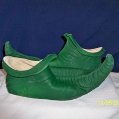 a pair of green shoes sitting on top of a white sheet