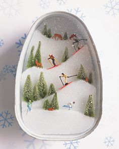 an ornament with skiers and trees in the snow on it's side