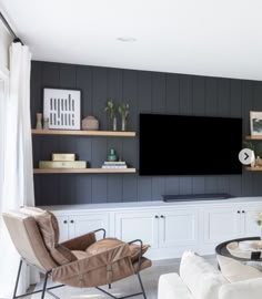 a living room filled with furniture and a flat screen tv mounted on a wall above a fireplace