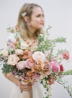 a woman holding a bouquet of flowers in her hands