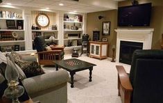 a living room filled with furniture and a flat screen tv mounted on the wall above a fireplace