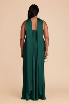 a woman in a green dress with her back to the camera