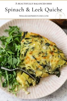 spinach and leek quiche on a white plate with a fork next to it