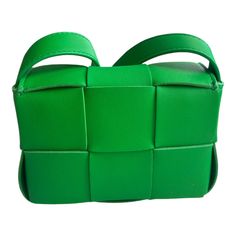 Experience the luxurious craftsmanship of the Bottega Veneta Candy Cassette Mini Bag in Green. Made from premium woven grained lambskin, this messenger bag offers a vibrant and eye-catching color. With an adjustable shoulder strap and a card slot pocket, it's the perfect combination of practicality and style. The fold-over flap and magnetic closure ensure the safety of your belongings. Measuring H3.5 x W5 x D2 inches, this bag is the epitome of designer excellence with its iconic Intrecciato wea Designer Rectangular Shoulder Bag With Intrecciato Weave, Modern Green Bag With Intrecciato Weave, Green Intrecciato Weave Modern Bag, Designer Square Bag With Woven Leather, Designer Square Bags With Woven Leather, Designer Woven Leather Square Bag, Luxury Rectangular Box Bag With Braided Handles, Rectangular Intrecciato Shoulder Bag For Shopping, Rectangular Intrecciato Weave Shoulder Bag For Shopping