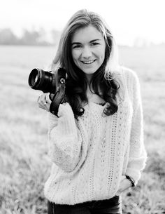 black and white photograph of a woman holding a camera