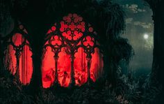 an image of a gothic window with red light coming from the windows and people in it