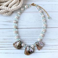 Real abalone seashells, mother of pearl, and imitation sea glass beads create this soft-toned, beach-themed statement necklace. Imagine this abalone vacation necklace styled with a white dress or blouse for an evening dinner after a day at the beach! Thank you for visiting Lenora Dame on Etsy! ~18.5-inches with 3-inch extension Beach Shell Necklace Made Of Mother Of Pearl, Mother Of Pearl Shell-shaped Necklace For The Beach, Bohemian Adjustable Sea Glass Necklaces, Beach Shell Necklace With Mother Of Pearl, Beaded Sea Glass Jewelry For Beach, Beach Beaded Sea Glass Jewelry, Adjustable Mother Of Pearl Shell Necklace For Beach, Ocean-inspired Pearl Necklace For Beach, Ocean-inspired Beaded Shell Necklace