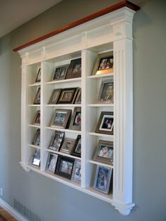 a white bookcase with many pictures on it