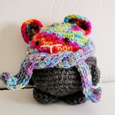 a crocheted stuffed animal wearing a hat and scarf