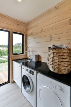 a washer and dryer in a room with wood paneling on the walls