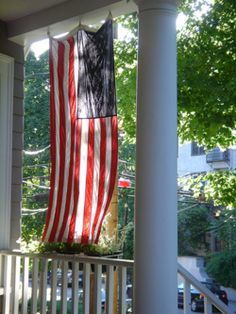 an american flag hanging on the front porch