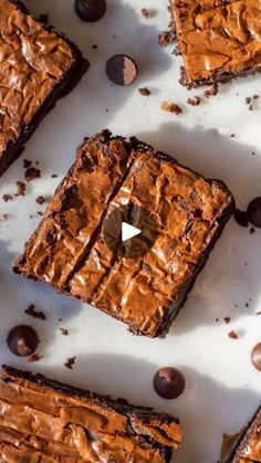 chocolate brownies are arranged on a sheet of parchment paper