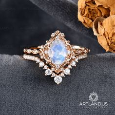 a ring with an oval stone surrounded by smaller round stones and small white diamond accents