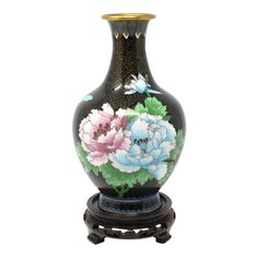 a black vase with flowers painted on it