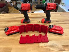 two red drillers sitting on top of a wooden table