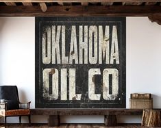 an old sign that says oklahoma oil co on the wall in a room with wooden floors