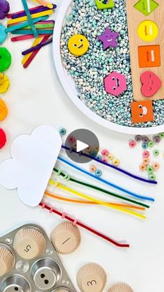 an assortment of crafting supplies including cupcakes, beads and paper hearts on a white table