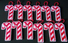 six red and white striped christmas ornament hangings on a black table top