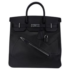 Mightychic offers an Hermes limited edition HAC Rock Birkin 40 (Haut a Courroies) bag featured in Black and Volupto leather. The bag features a diagonal saddle shaped zippered pocket in front, tonal stitching and double rolled handles. Inside the bag has a detachable fastened pocket on a key chain and is lined in black chevre leather. At rear the bag has 1 zippered pocket. This tote bag is neutral perfection for everyday to travel wear. This Hermes Hac bag is accentuated with crisp palladium har Hermes Hac 40, Black Hermes Birkin, Hermes Evelyn Bag Black, Hermes Bags Black, Hermes Birkin 25 Sellier Black, Travel Wear, Hermes Box, White Mark, Black Bag