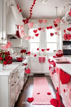 a kitchen filled with lots of red hearts hanging from the ceiling