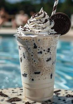 an ice cream sundae with oreo cookies and milkshake on the table