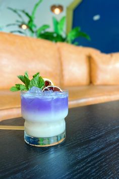 a purple drink sitting on top of a wooden table