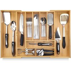 a wooden drawer filled with kitchen utensils