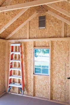 a ladder is in the corner of a room that has been framed with plywood