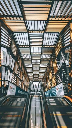 an escalator in a building with lots of windows