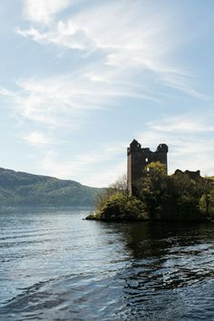 an old castle sitting on top of a small island in the middle of a lake