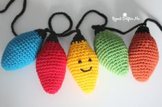 four crocheted christmas lights with smiling faces