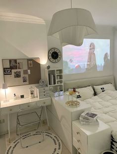 a bedroom with a bed, desk and large screen