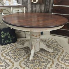 a white table with a wooden top on a rug